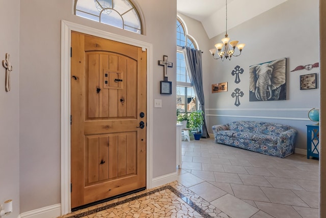 foyer with lofted ceiling, a notable chandelier, plenty of natural light, and light tile patterned flooring