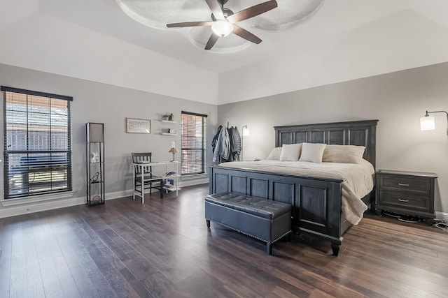 bedroom featuring dark hardwood / wood-style flooring, a tray ceiling, and ceiling fan