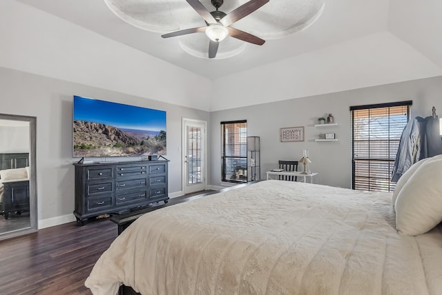 bedroom with a raised ceiling, dark hardwood / wood-style floors, access to exterior, and ceiling fan