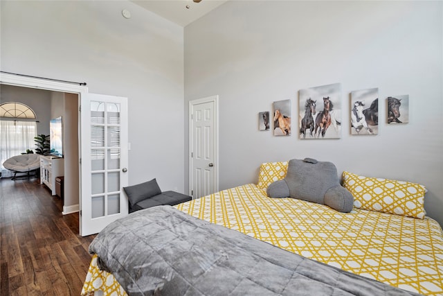 bedroom featuring dark hardwood / wood-style floors and a high ceiling