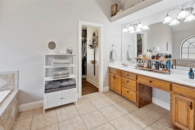 bathroom featuring a chandelier, vanity, tiled bath, and tile patterned floors