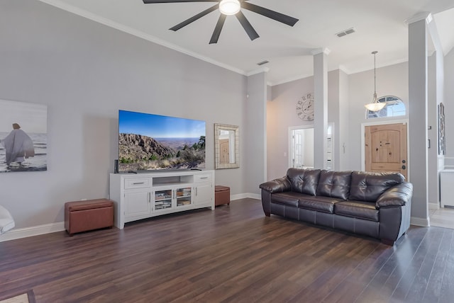 living room with crown molding, a towering ceiling, dark hardwood / wood-style flooring, and ceiling fan