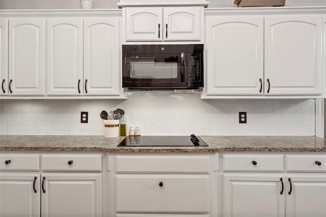 kitchen with black appliances, decorative backsplash, white cabinets, and light stone counters