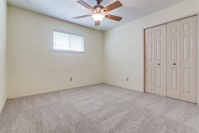 unfurnished bedroom featuring a closet, carpet floors, and ceiling fan