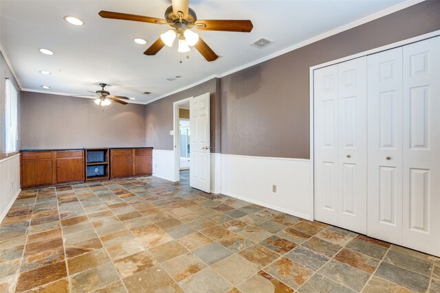 unfurnished living room with dark tile patterned floors, crown molding, and ceiling fan