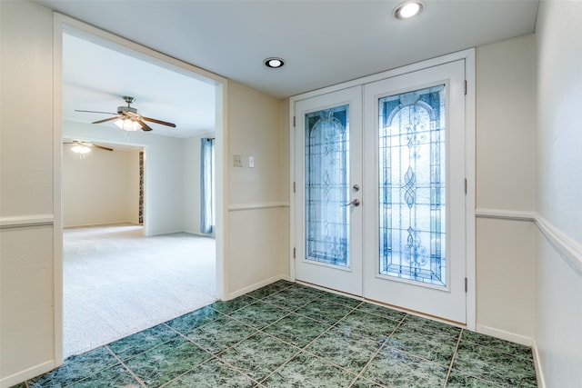 doorway featuring dark tile patterned floors, french doors, and ceiling fan