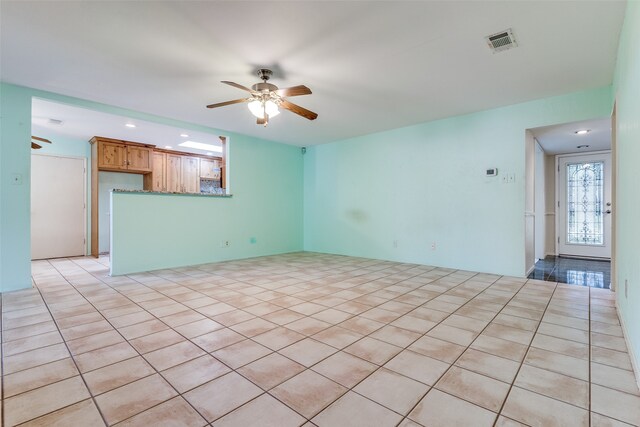 unfurnished living room with light tile patterned floors and ceiling fan