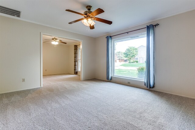 carpeted empty room featuring ceiling fan and ornamental molding