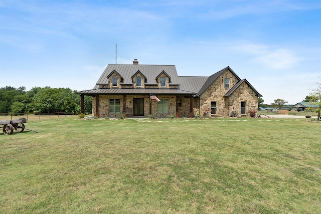 view of front of house with a chimney, metal roof, a standing seam roof, and a front yard