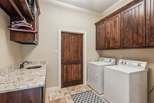 washroom with cabinets, independent washer and dryer, and sink