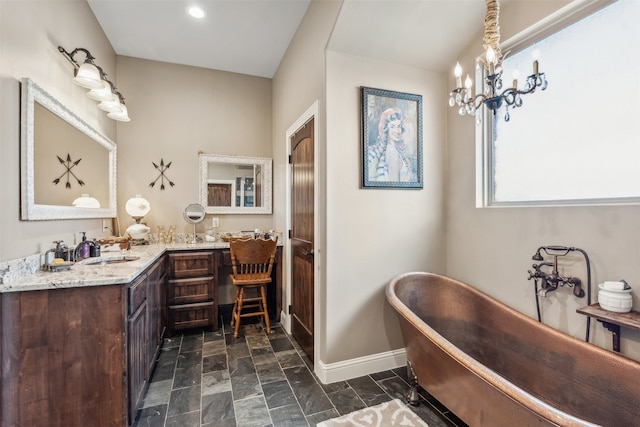 bathroom with vanity, a bath, and an inviting chandelier