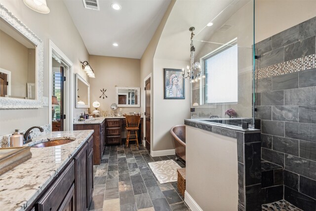 bathroom with a tile shower, vanity, and a notable chandelier