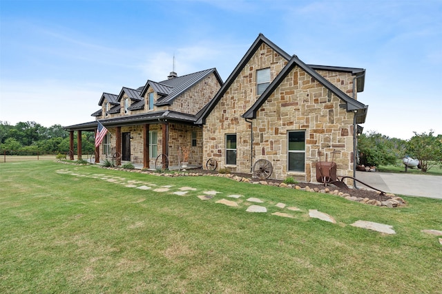 view of front facade with a standing seam roof, metal roof, and a front lawn