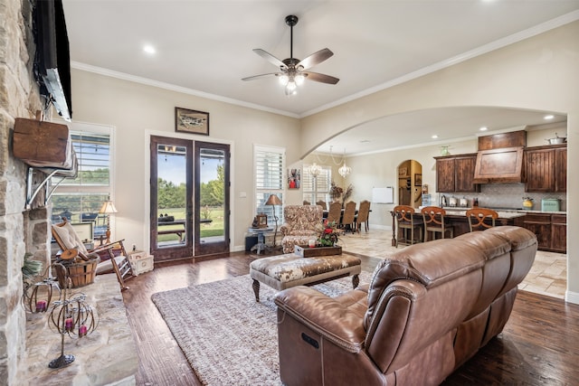 living room featuring ceiling fan, wood-type flooring, and crown molding