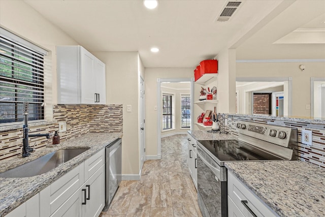 kitchen featuring sink, white cabinetry, backsplash, stainless steel appliances, and light stone counters