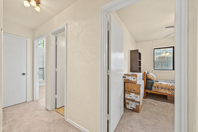 hall with light colored carpet