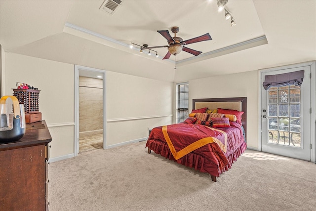 bedroom featuring ceiling fan, a raised ceiling, light carpet, and multiple windows