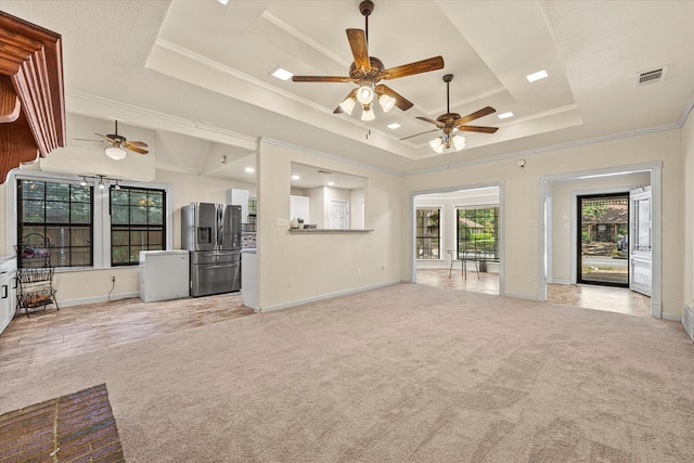 unfurnished living room featuring a raised ceiling, ornamental molding, light carpet, and ceiling fan