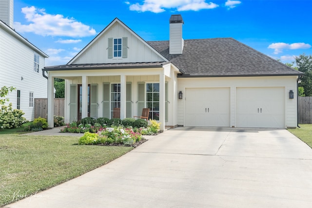 view of front of property featuring a porch, a front yard, and a garage