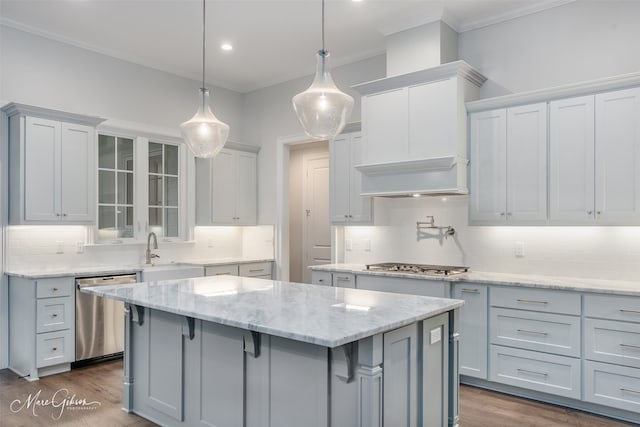 kitchen featuring decorative light fixtures, a center island, backsplash, and appliances with stainless steel finishes