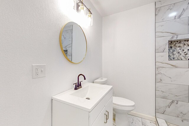 bathroom featuring vanity, tile patterned flooring, and toilet