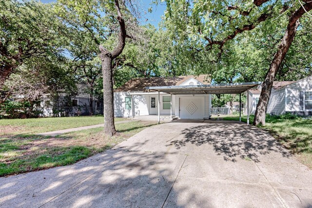 ranch-style home featuring a carport and a front yard