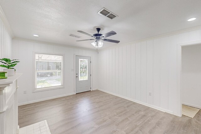 entryway featuring ceiling fan, crown molding, a textured ceiling, and light hardwood / wood-style flooring