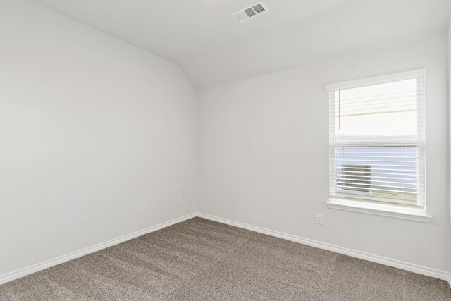 unfurnished room featuring carpet and lofted ceiling