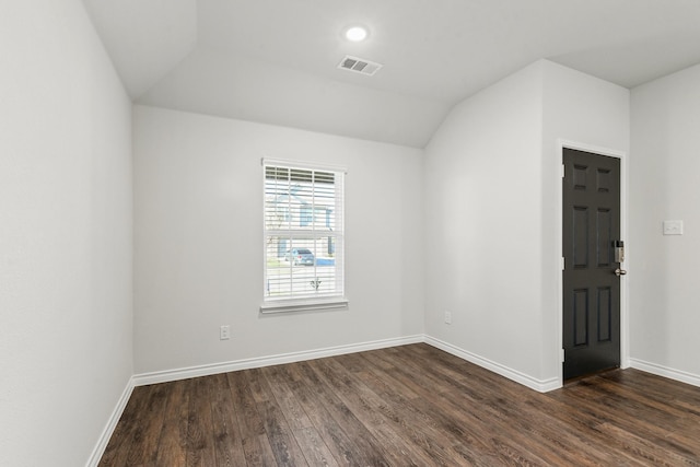 spare room with lofted ceiling and dark hardwood / wood-style floors