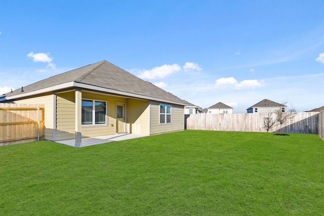 rear view of house featuring a lawn and a patio