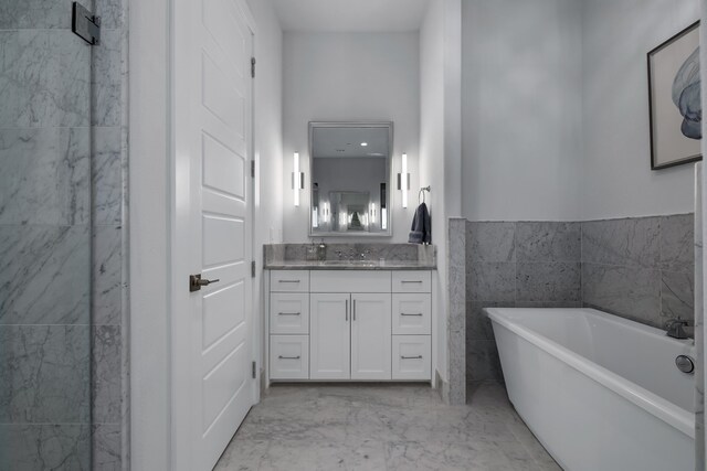 bathroom featuring vanity, tile patterned flooring, tile walls, and a tub