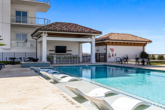 view of swimming pool featuring a patio, a gazebo, and an outdoor bar