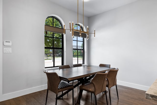 dining space featuring dark wood-type flooring and a notable chandelier