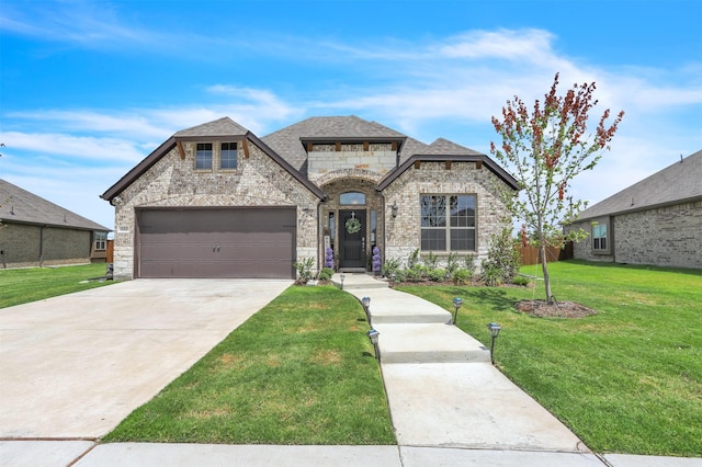 french provincial home with a garage and a front lawn