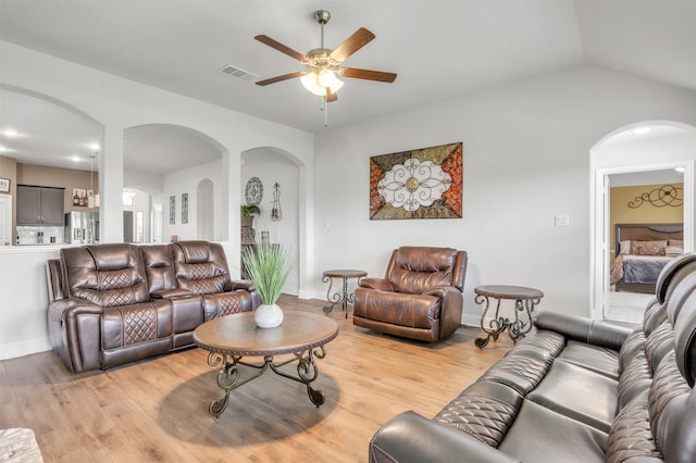 living room with lofted ceiling, light hardwood / wood-style floors, and ceiling fan