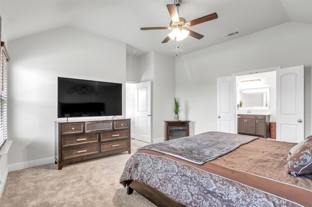 carpeted bedroom with sink, ensuite bath, ceiling fan, and vaulted ceiling