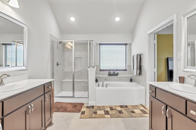 bathroom featuring tile patterned flooring, lofted ceiling, double sink vanity, and plus walk in shower