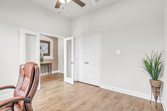 office with ceiling fan, a high ceiling, and light hardwood / wood-style flooring