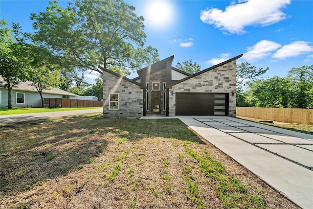 modern home featuring a garage and a front lawn