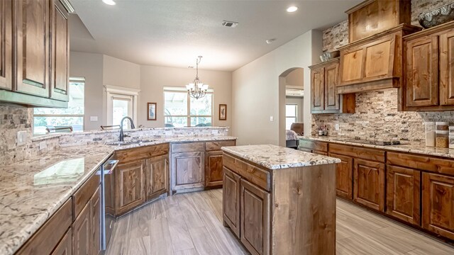 kitchen with sink, black electric stovetop, a wealth of natural light, and decorative backsplash