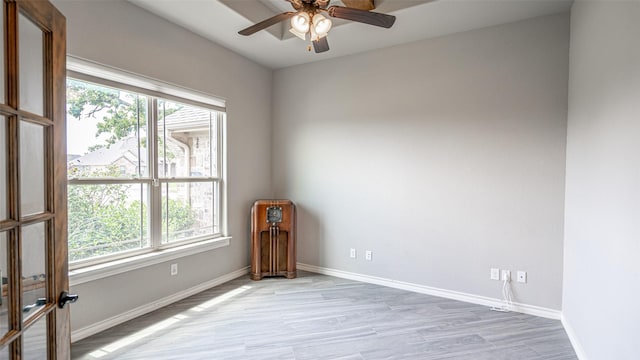 spare room with a wealth of natural light, ceiling fan, and hardwood / wood-style floors