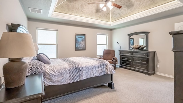 bedroom featuring light colored carpet, ceiling fan, and a tray ceiling