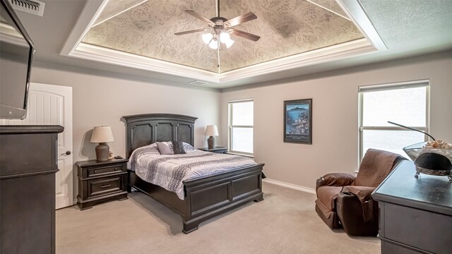 bedroom with light carpet, ceiling fan, a raised ceiling, and a textured ceiling