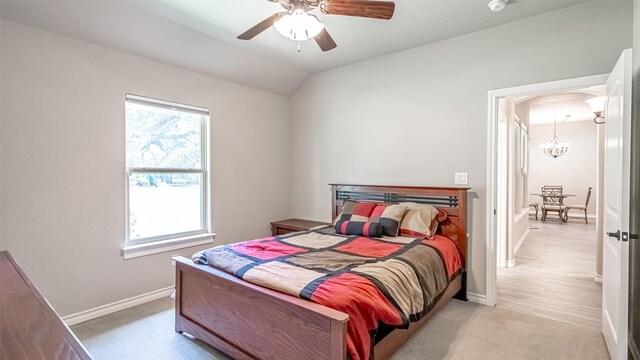 bedroom featuring ceiling fan with notable chandelier, light carpet, and multiple windows