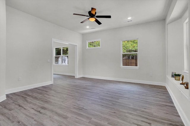 unfurnished room featuring visible vents, baseboards, a ceiling fan, and wood finished floors