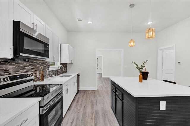 254 19th St SE, Paris, TX 75460 - kitchen featuring appliances with stainless steel finishes, a sink, white cabinets, light countertops, and recessed lighting