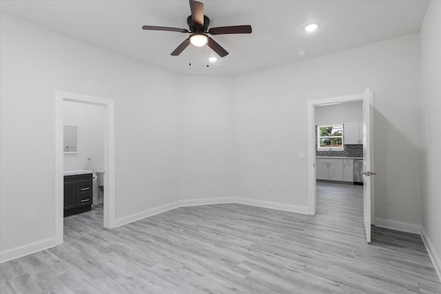 unfurnished room featuring light wood-type flooring, ceiling fan, and sink