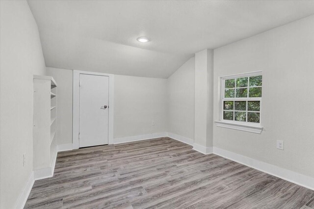 254 19th St SE, Paris, TX 75460 - bonus room featuring lofted ceiling, wood finished floors, and baseboards