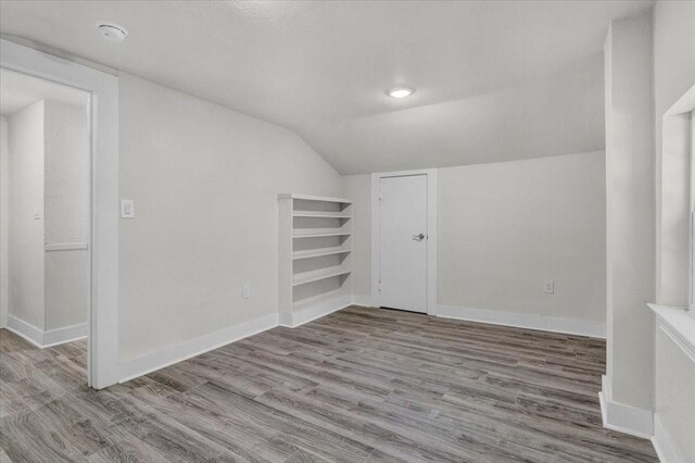 254 19th St SE, Paris, TX 75460 - bonus room with vaulted ceiling, wood finished floors, and baseboards