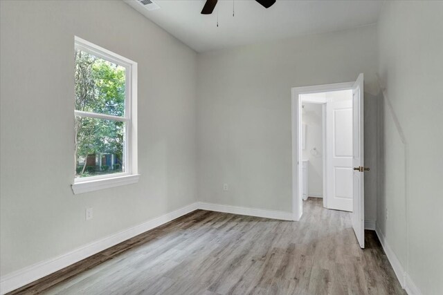 unfurnished room with a ceiling fan, light wood-type flooring, and baseboards